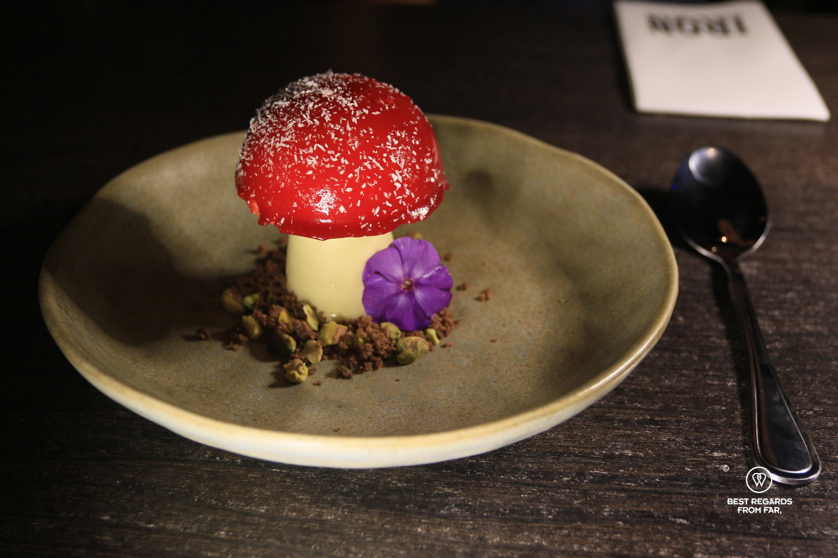 Dessert of white chocolate and raspberry shaped as a mushroom.