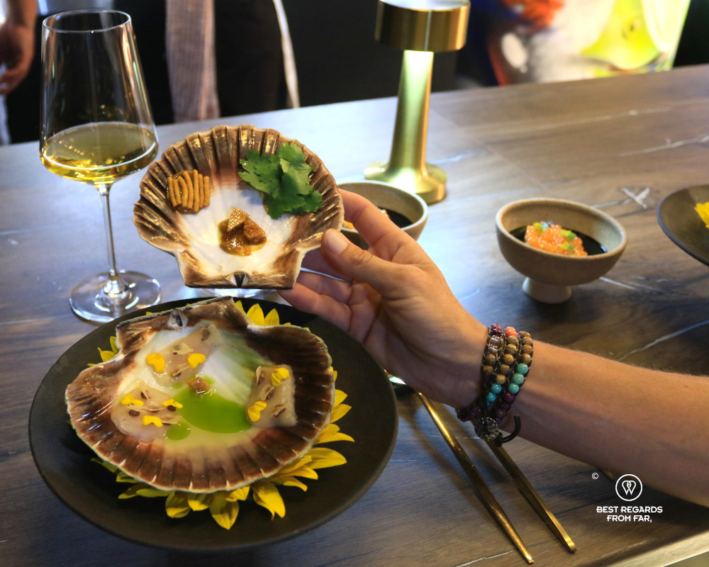 Patron opening a scallop at The Wiggle Room, Cape Town.