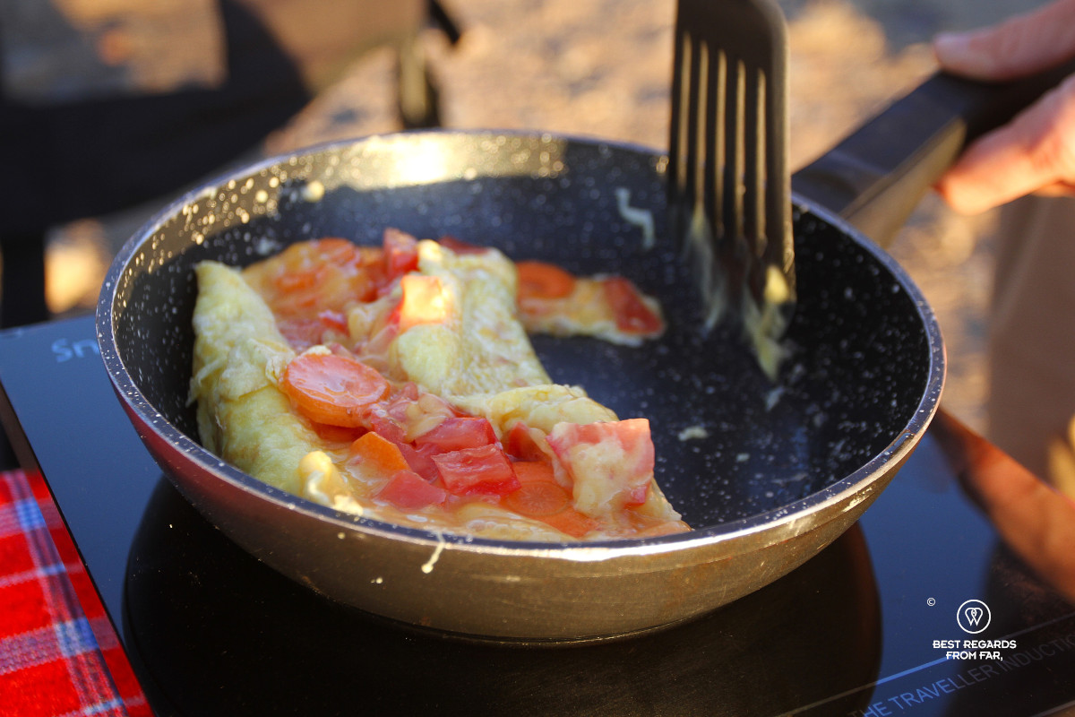 Am omelette with tomato being cooked in the outdoors on induction.