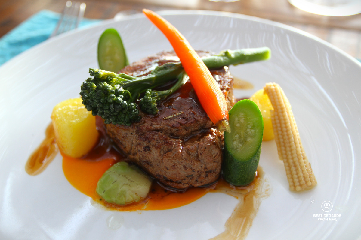 A steak for dinner at Rogge Cloof with veggies on top.