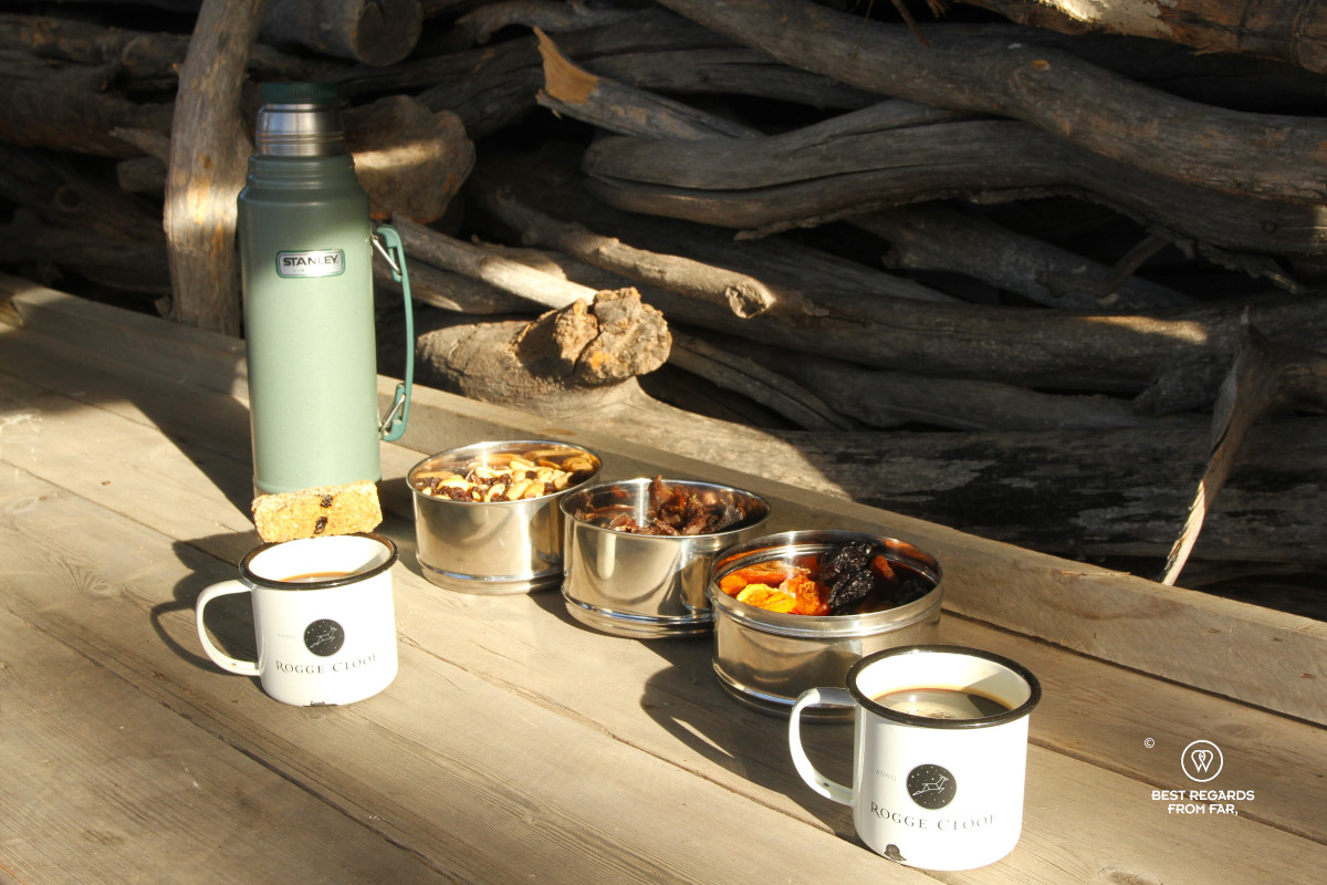A snack during a sunrise game drive at Rogge Cloof with a thermos, coffee mugs and bites.