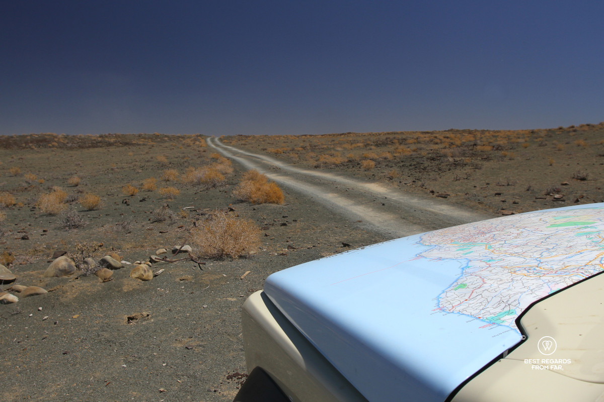 Gravel road with the bonnet of a car with a printed map on it.
