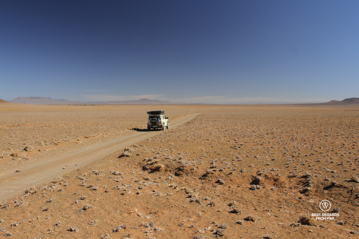 A Suzuki Jimny on a gravel road in the middle of nowhere.