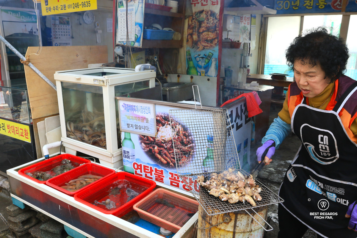 Older woman preparing food on the Busan Jagalchi market.