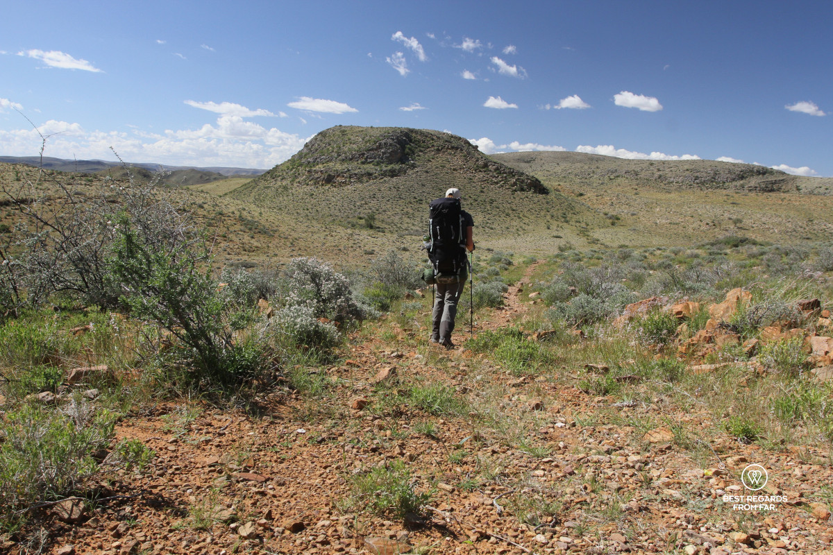 Hiker along the Naukluft 8-day Trail crossing a wide open plain.