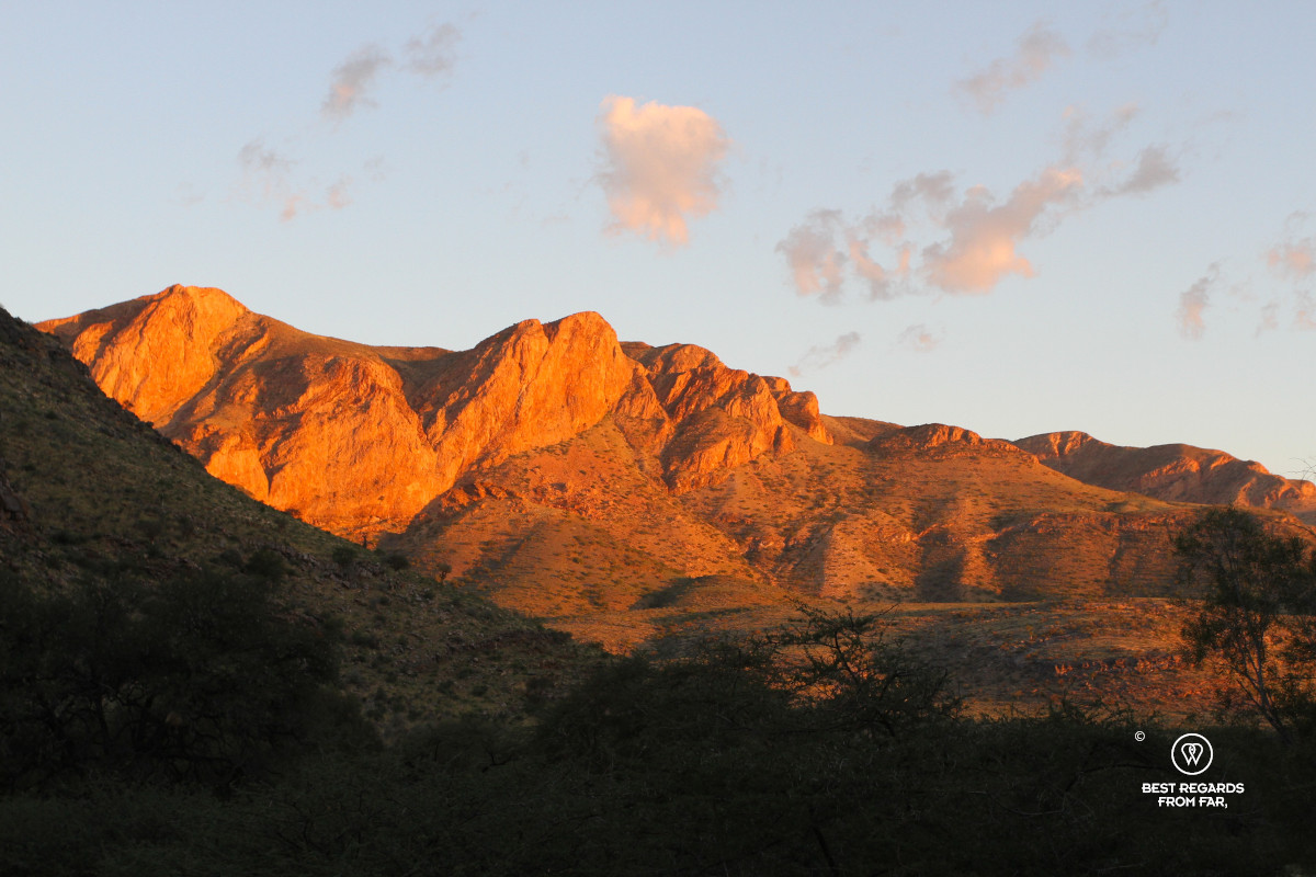 Mountains tainted in ocre color during a dramatic African sunset.
