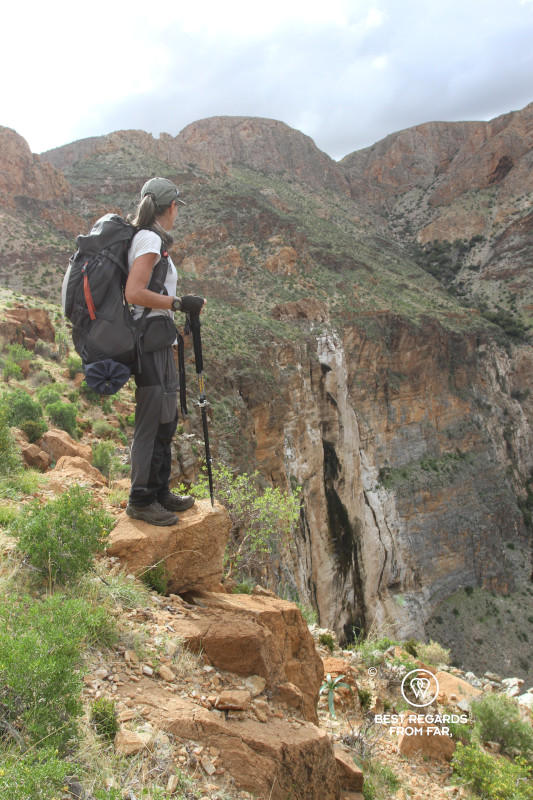 Author Claire Lessiau carrying a heavy backpack along the 8-day Naukluft Trail and taking a moment to look at the dry waterfall.