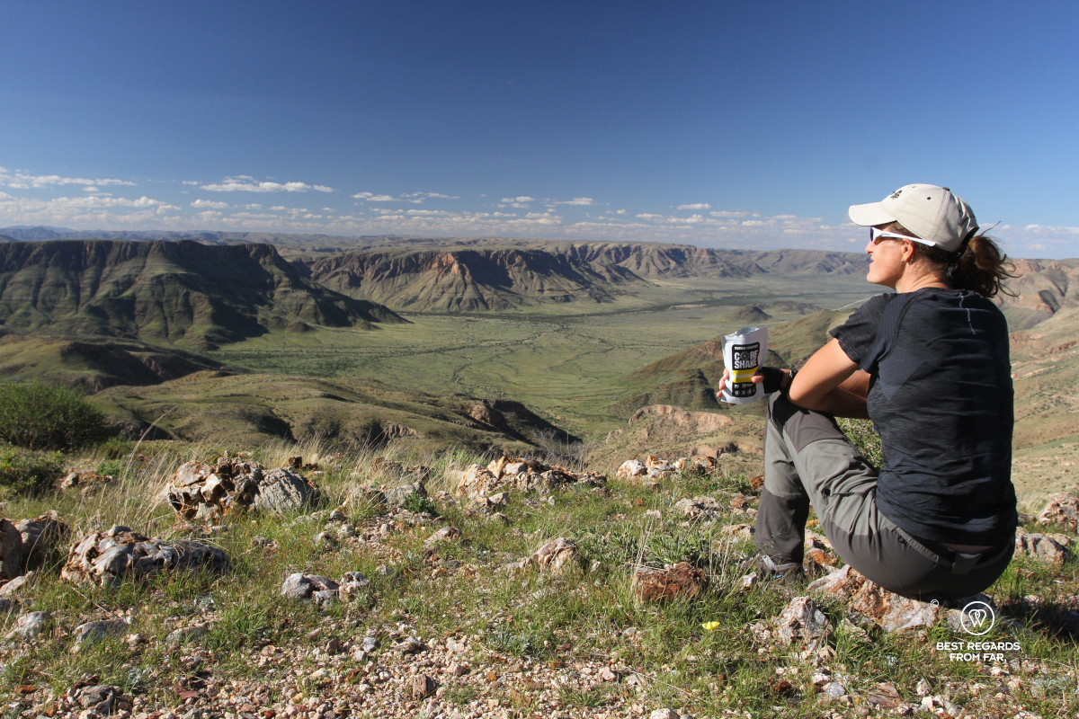 Author Marcella van Alphen taking in the view on a green valley along a hiking trail.