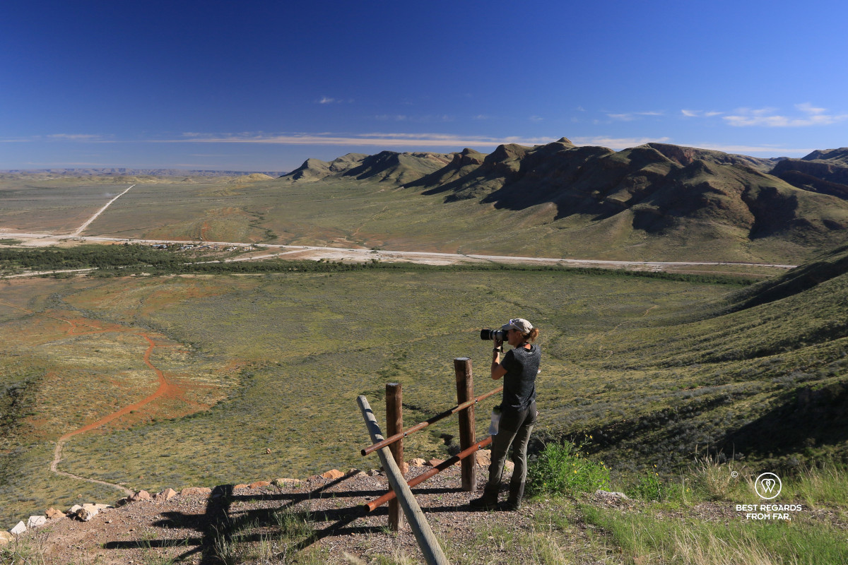 Photographer Marcella van Alphen taking a photo of the BuellsPort lodge & farm with the Naukluft mountains in the background.