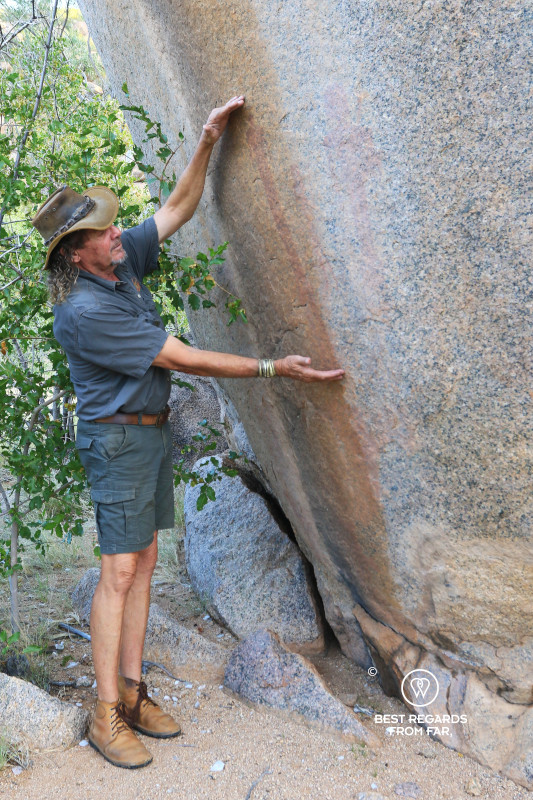 Huab Lodge owner Deon Brummer showing an ancient rock painting on a granite boulder.