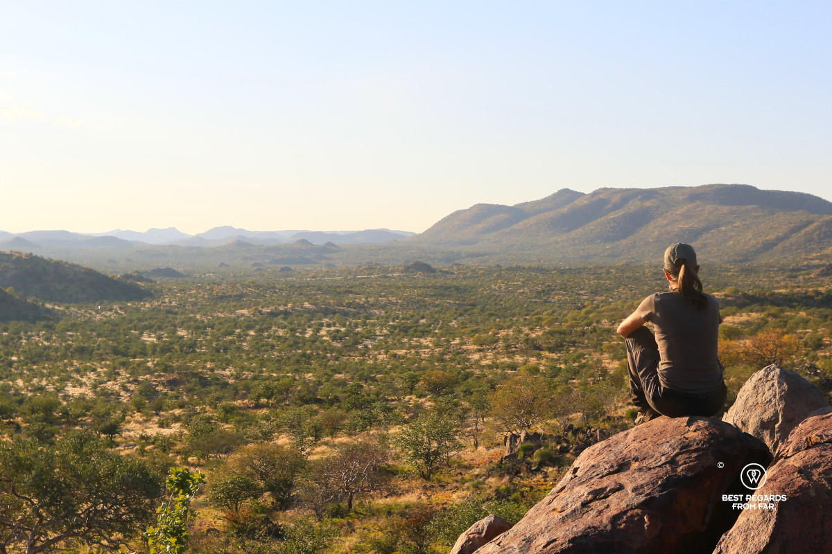 Cofounder Claire Lessiau seen from the back seated on a rock overlooking the African Damaraland.