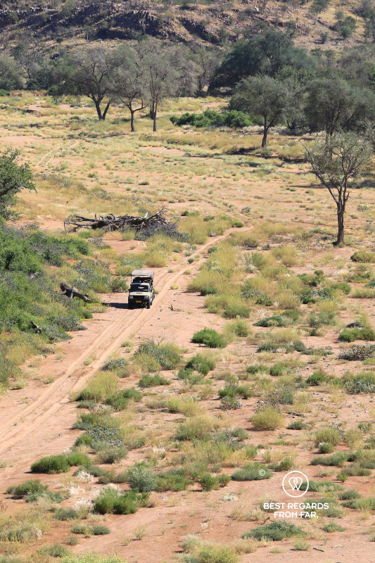 Toyota Land Cruiser driving through a dry riverbed in Namibia.