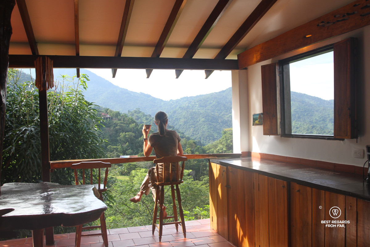 Author Claire Lessiau enjoying coffee from a bar stool with a view on the Sierra Nevada de Santa Marta from a suite in Mundo Nuevo, Colombia.
