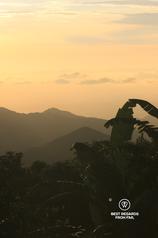 Orange sunset sky with mountains in the background.