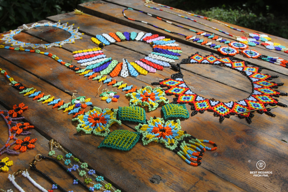 Colorful handicrafts made by Wiwa poeple on display on a wooden table.