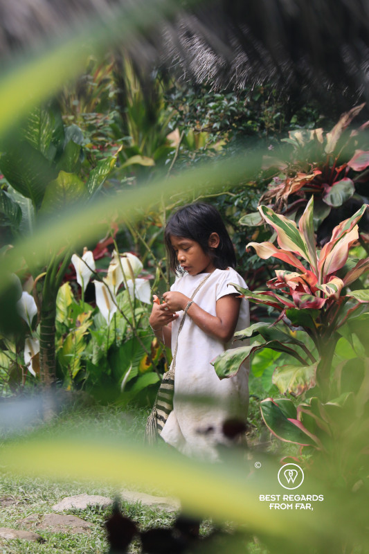 Wiwa Indigenous child wearing traditional white clothes and a traditional shoulder bag.