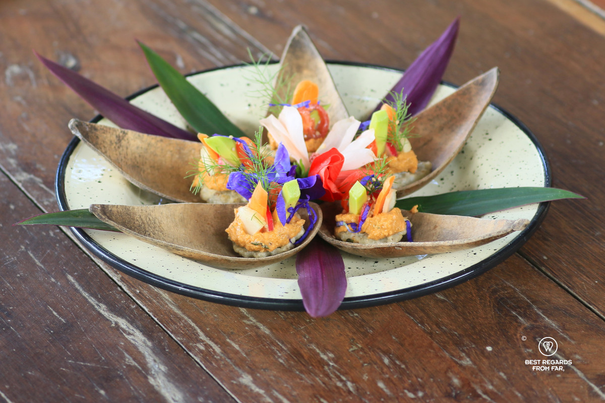 Dish with arepitas with pigeon pea, sundried tomato hummus and garden vegetables.