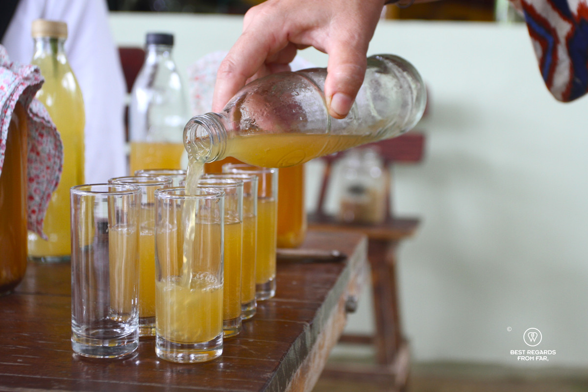 Kombucha being served in glasses from a glass bottle.
