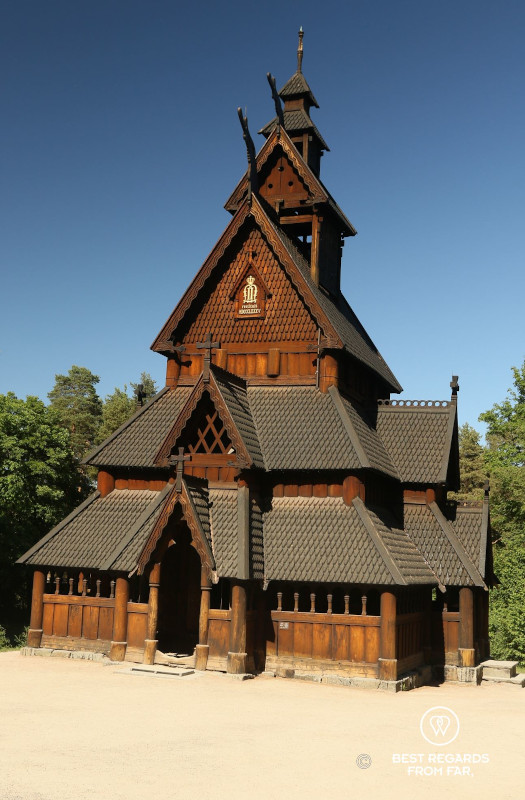 Traditional Norwegian wooden Stave Church against blue skies.