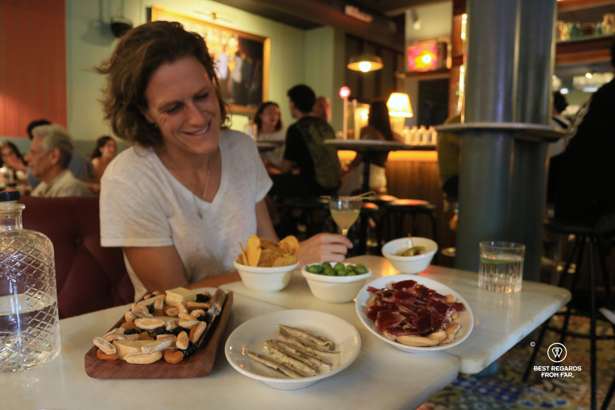 Table filled with tapas and cheese platter in a trendy bar.