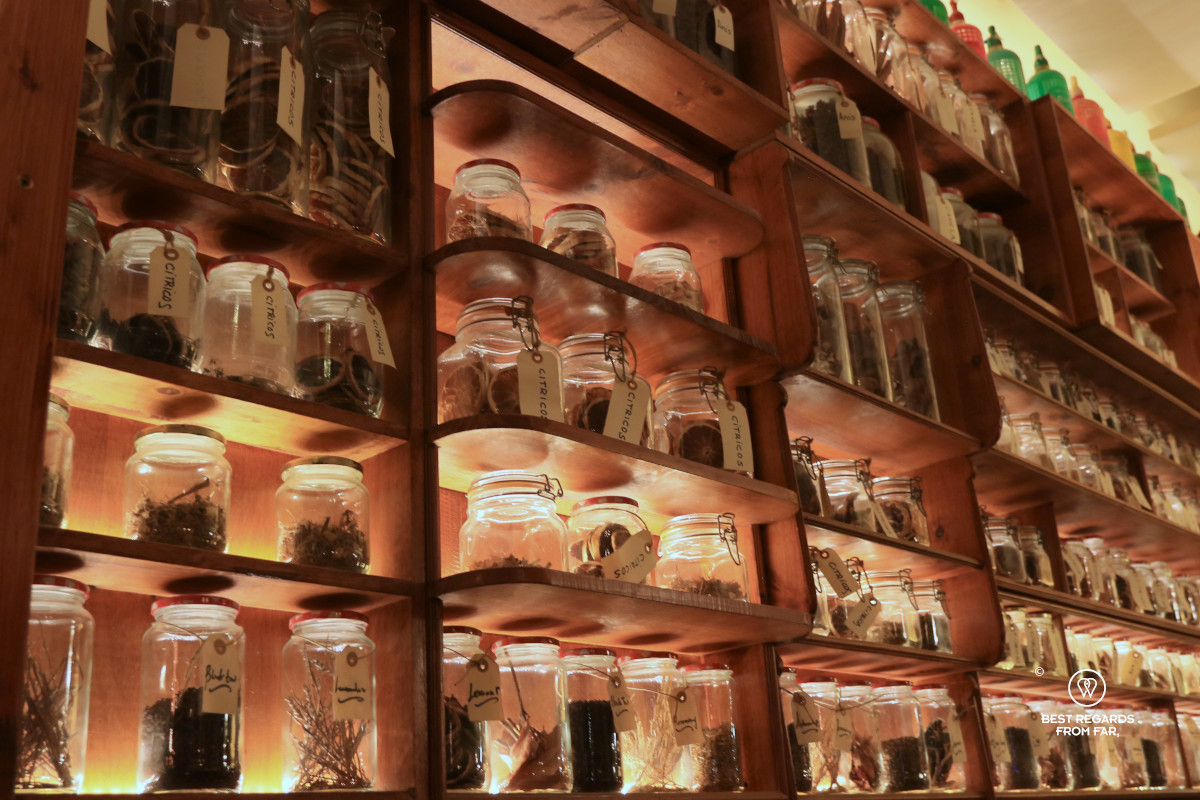 Wooden cabinet filled with glass jars that are lit.