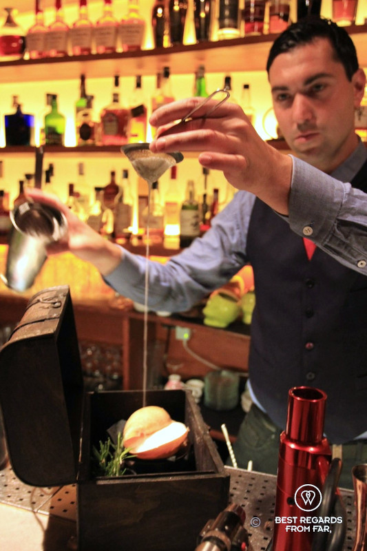 Barman mixing the Mediterranean Treasure cocktail at El Paradiso speakeasy bar in Barcelona.